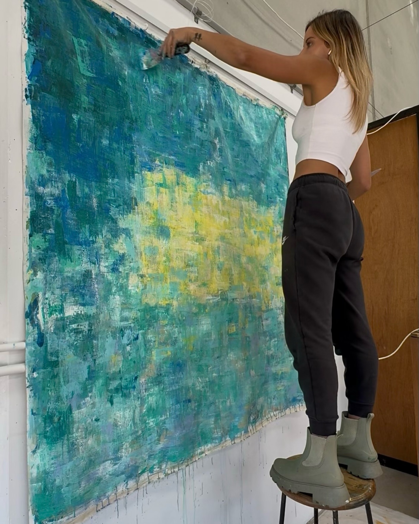 Gabrielle May working on a pink abstract canvas