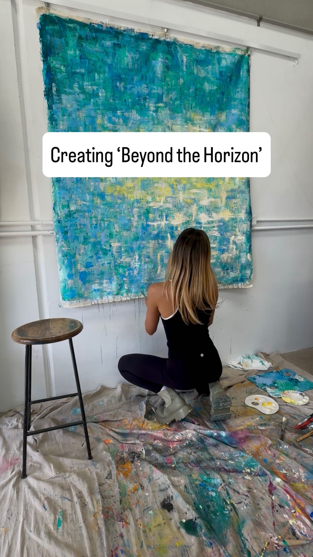 Gabrielle May beside finished artworks in studio